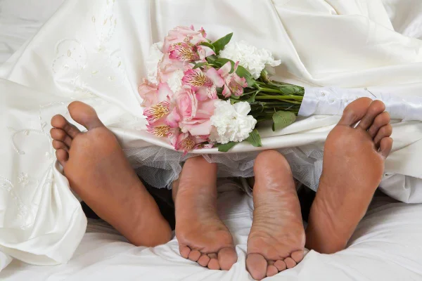 Foto colorida de duas pessoas e um buquê de flores - Metrópoles