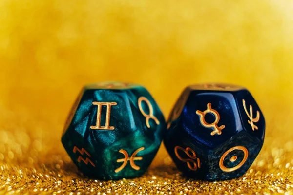 na foto temos dois dados oitavados com simbolos de signos desenhados