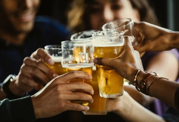 foto colorida - varios copos de vidro com cerveja fazendo brinde pelo dia internacional da cerveja - Metrópoles