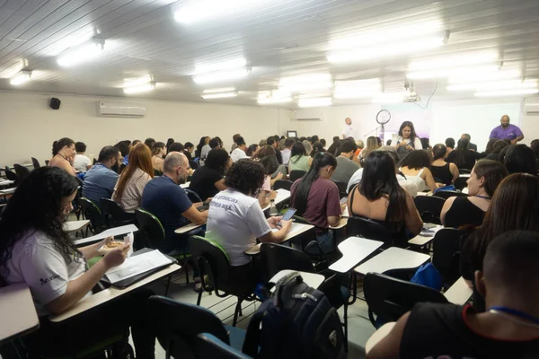 Sala com várias pessoas sentadas - Metrópoles