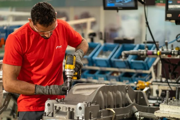 Profissional na linha de montagem de uma fábrica de motores