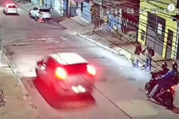 Iamgem colorida mostra assaltantes, em cima da moto, e vítimas mais à frente - Metrópoles