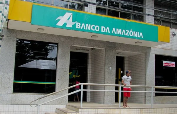 Fachada de agência Banco da Amazônia com homem de bermuda vermelha e camiseta branca