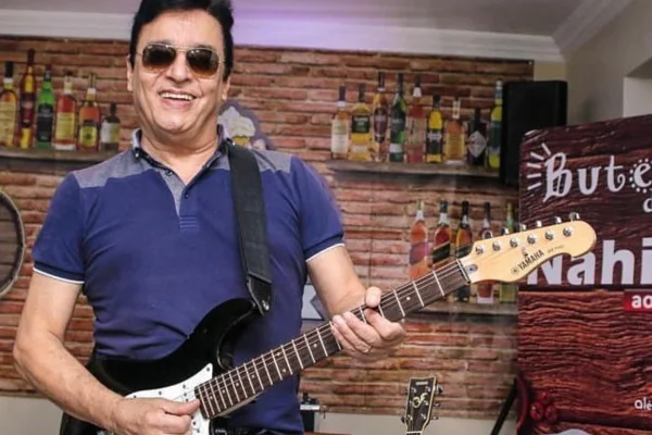 Cantor Nahim posa com sua guitarra e óculos escuros - Metrópoles
