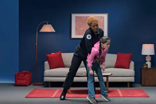 Imagem mostra uma profissional salvando uma menina de engasgo. Metrópoles