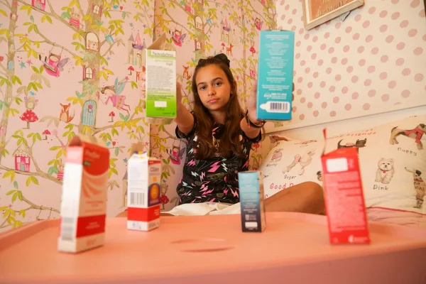 Menina de cabelos lisos segura embalagens de remédios
