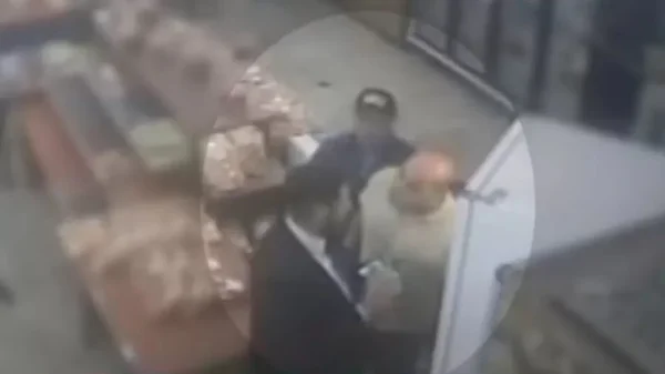 Imagem de câmera de segunça mostra três homens no interior de uma padaria; um veste terno preto, outro camiseta clara e o último um boné preto - Metrópoles
