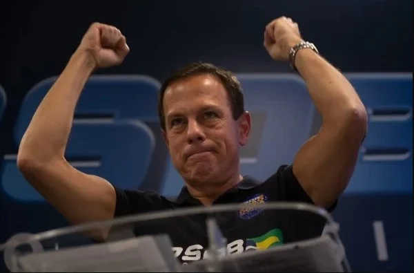 João Doria, governador de São Paulo. Ele veste camiseta escura e está de mascara - Metrópoles
