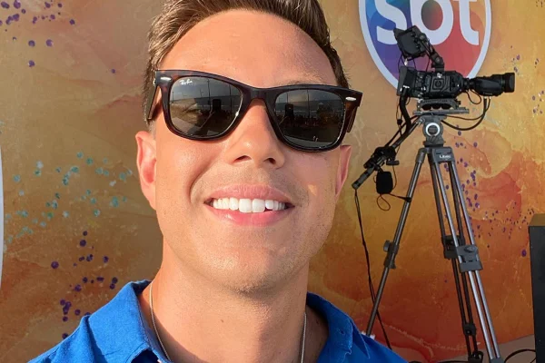 Gabriel Cartolano posa de óculos escuros nos bastidores de mais uma cobertura pelo SBT - Metrópoles