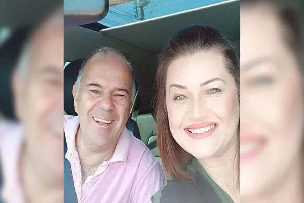 Imagem colorida, casal sorrindo em carro - Metrópoles