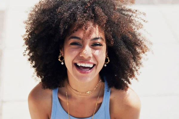 Mulher negra de cabelos soltos sorridente
