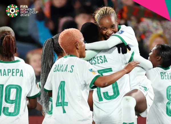 Imagem colorida de jogadoras da Zâmbia comemorando um gol
