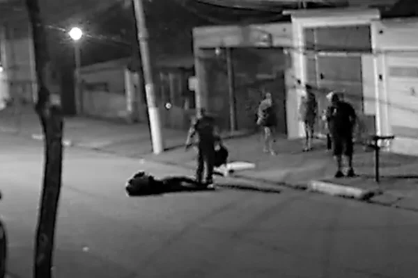 Imagem preto e branco de homem caído em asfalto - Metrópoles