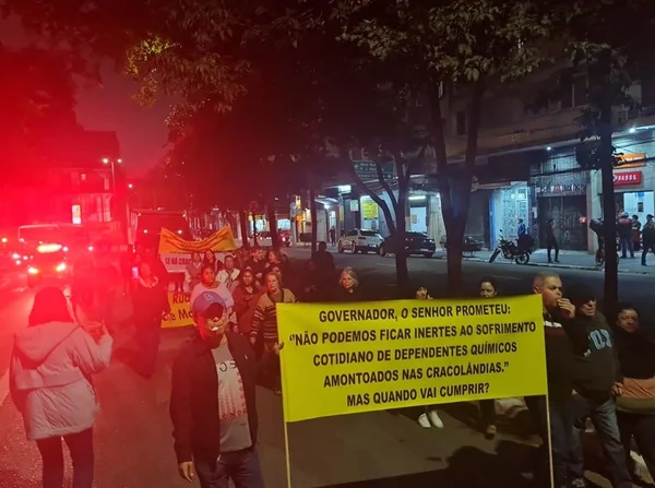 Imagem mostra pessoas caminhando, com faixa amarela nas mãos, em protesto na região central de São Paulo