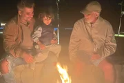 Bruno Galiasso posa com o pai. Paulo César Marques, e um de seus filhos em frete à fogueira