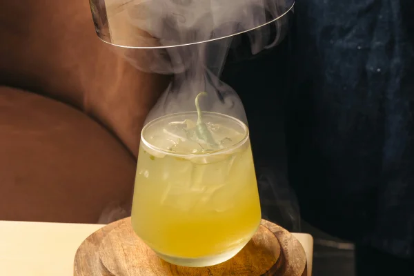 Foto colorida de drink amarelo e fumaça feita concitrogênio líquido - Metrópoles