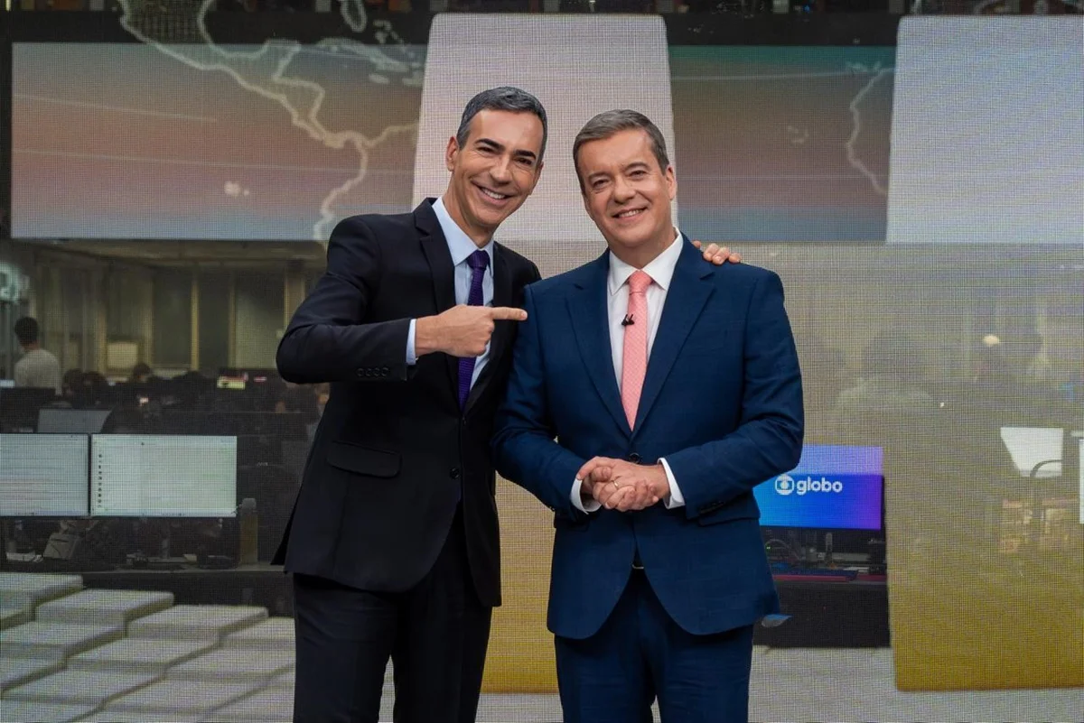 Imagem colorida dos jornalistas César Tralli e Roberto Kovalick no estúdio do Jornal Hoje