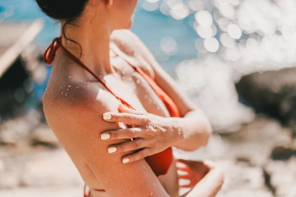 Mulher de biquíni com braços cruzados na praia - Metrópoles