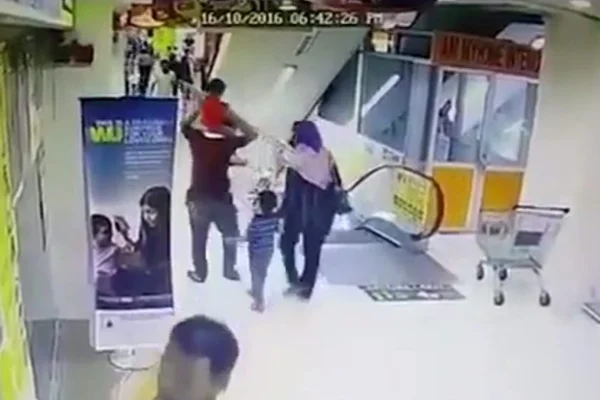 Criança cai dos ombros do pai após acidente em escada rolante