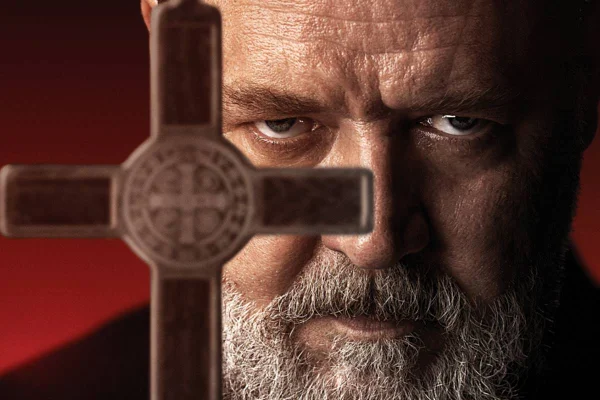 Na imagem colorida, Russell Crowe aparece segurando cruz em postêr do filme O Exorcismo - Metrópoles