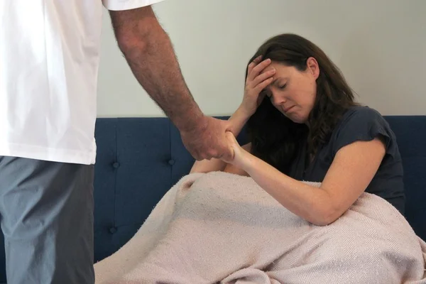Mulher com uma mão na cabeça e outra segurando mão de homem - Metrópoles