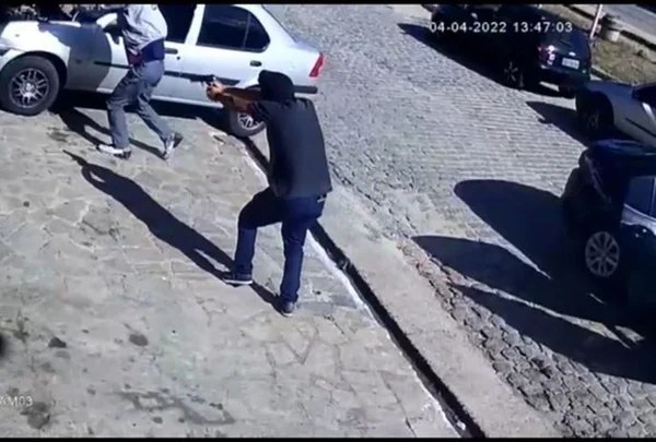 print de um vídeo em que um homem aponta uma arma para o outro e logo em seguida dispara