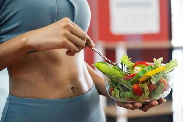 Foto mulher segurando tigela de vidro com verduras e legumes dentro - Metrópoles - comida saudável