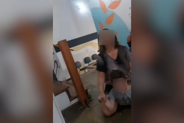 Imagem colorida de mulher em cima de criança autista no interior. Metrópoles