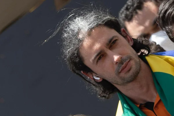 Rony, brasileiro que estava na Ucrânia em meio à guerra, é repatriado. Ele é visto desembarcando, com uma bandeira do Brasil nas costas, do avião da FAB que o trouxe com outros resgatados do conflito - Metrópoles