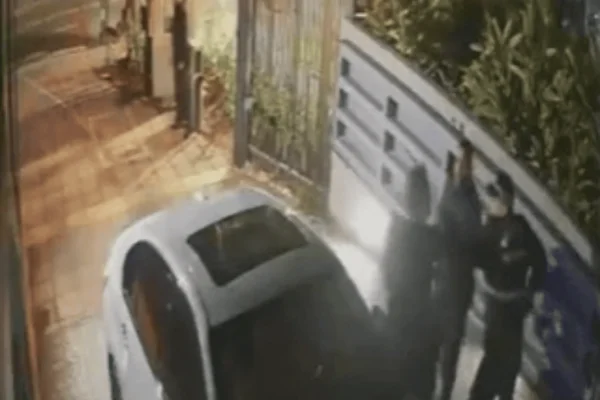 Imagem colorida de um homem brigando com GCMs após ser abordado em um carro branco - Metrópoles