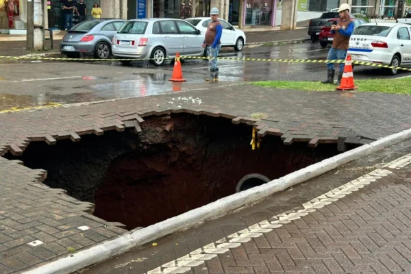 Foto colorida de cratera aberta em avenida no Paraná devido a chuvas fortes