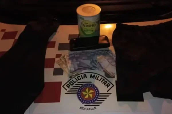 Imagem colorida mostra dinheiro e lata de leite em pó roubados por casal no interior de São Paulo - Metrópoles