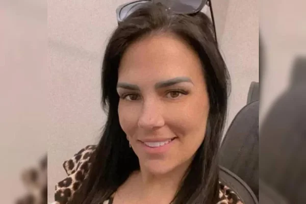 mulher sorrindo com óculos escuros na cabeça - Metrópoles