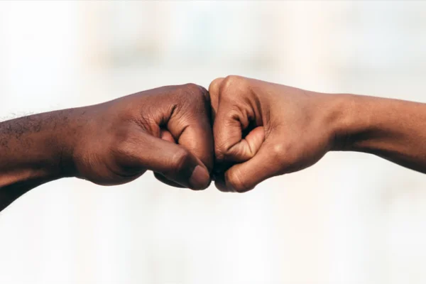 Imagem colorida de mãos dando soco