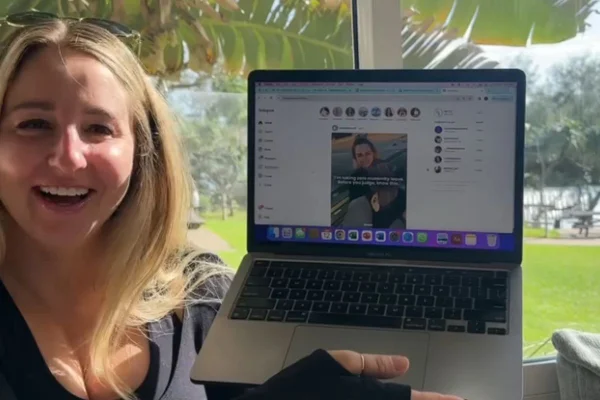 Foto colorida de uma mulher segurando o computador - Metrópoles