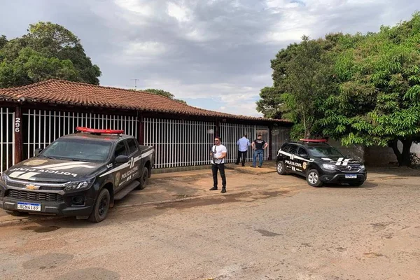 casa com policiais e viaturas na frente