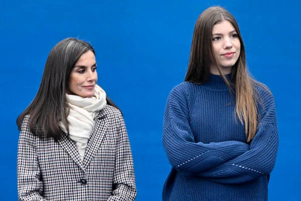 Foto colorida de mulher com blazer xadrez ao lado de mulher mais alta com casaco azul - Metrópoles