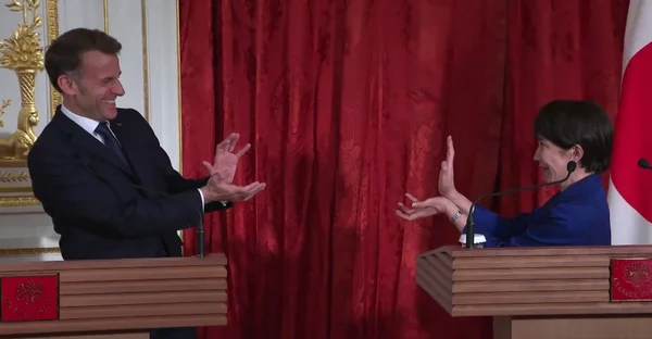 Imagem colorida mostra o presidente da França e a premier do Japão - Metrópoles