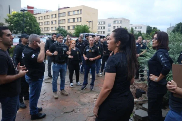 Imagem colorida mostra um grupo de homens e mulheres com roupas pretas da Polícia Civil de São Paulo. Megaoperação mira homens condenados por agressão contra as mulheres - Metrópoles