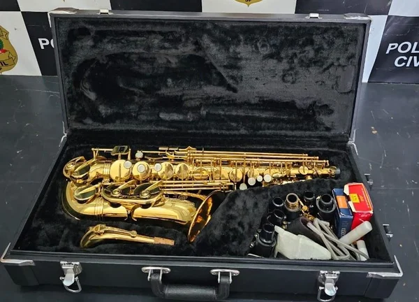 Imagem colorida mostra saxofone recuperado pela polícia dentro de uma mala - Metrópoles