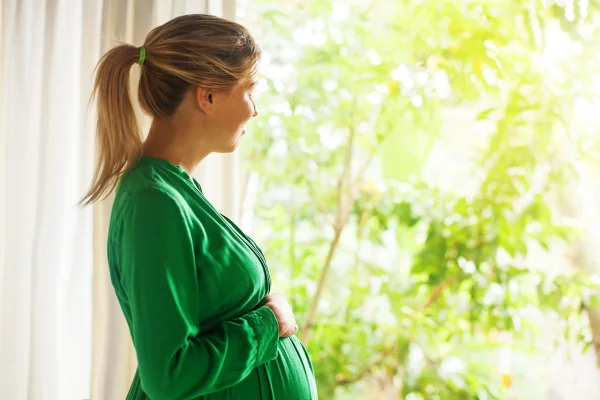 imagem colorida de mulher grávida vestindo uma roupa verde. Usar verde no Natal engravida?