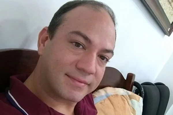 Foto colorida de homem com blusa gola polo vinho