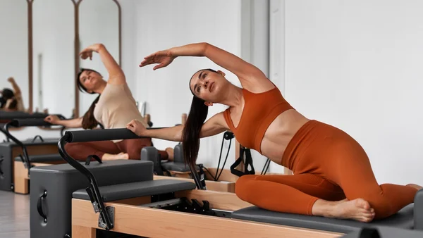Foto colorida de mulher praticando pilates