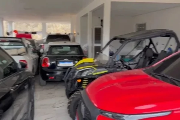Foto colorida de veículos na garagem de família de agiotas presos na Bahia