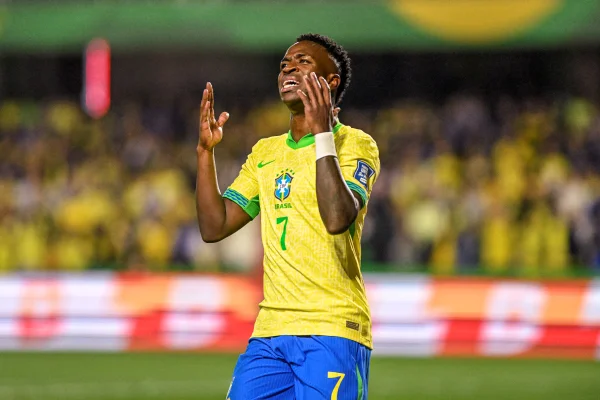 Foto colorida de Vini Jr. lamentando com a camisa da Seleção Brasileira - Metrópoles