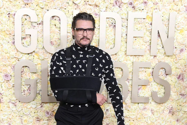 Pedro Pascal no tapete vermelho do Globo de Ouro 2024, usando tipoia no braço e com roupa preta - Metrópoles