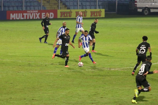 Jogadores correm em campo de futebol