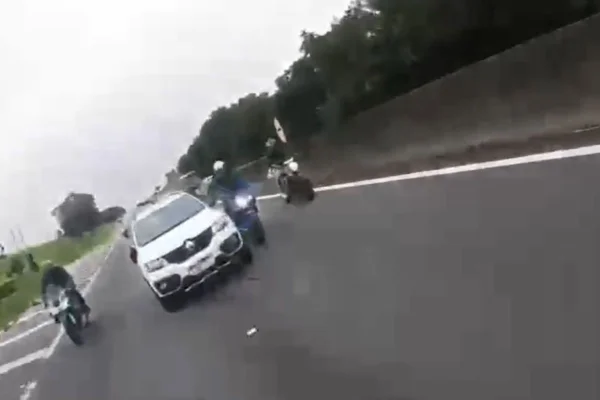 Print de imagem de vídeo em que carro Kwid branco ultrapassa uma moto na direita do carro em rodovia