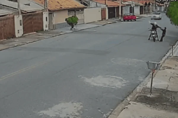 Imagem colorida de um motociclista assaltando uma idosa no meio da rua - Metrópoles
