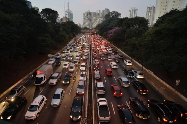 Imagem colorida mostra a 23 de Maio, avenida larga e repleta de carros em São Paulo, com a cidade ao fundo - Metrópoles